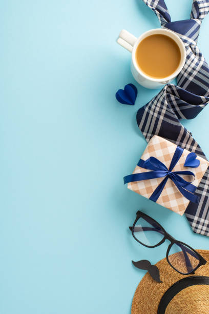 istock A vertical charming setup for Father's Day featuring a coffee cup, trendy glasses, and stylishly wrapped gifts on a pastel blue background 2149858785