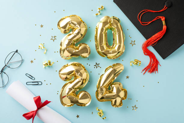 Eye-catching top view composition boasting 2024 gold balloons, graduation cap, diploma, stationery, specs and confetti on light blue background, perfect for graduation-themed or educational promotions