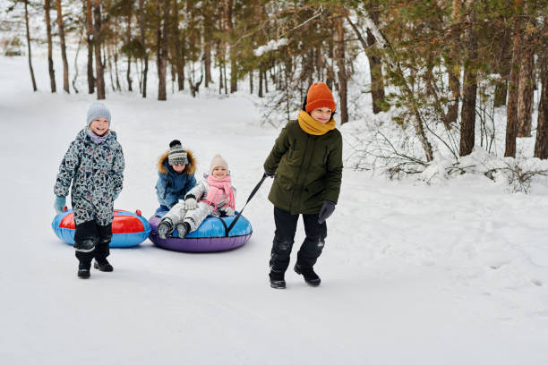 istock Kids pulling snow tubes in the forest 2149858995