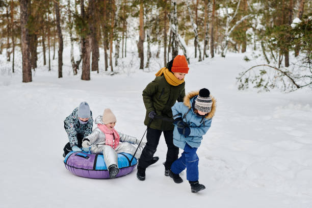 istock Two boys pulling snow tube with girl 2149859011