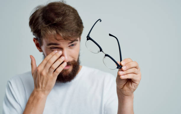 istock man with glasses in hand on a gray background vision problems eye pain diopter 2149859186