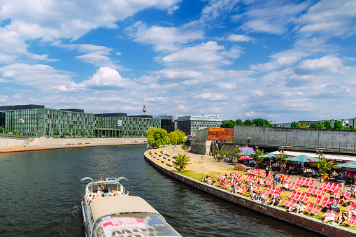 Berlin, Germany - June 07, 2023: Tour boats with tourists and Modern office buildings along the Spree river, Germany Near Main Train Station and government district