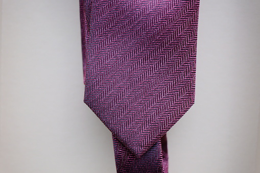 Classic tie fabric texture close-up with a business style pattern on a gray background
