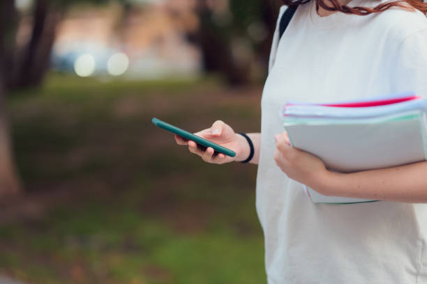 istock Woman holding folder and mobile phone 2149860765