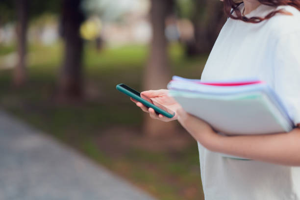istock Woman holding folder and mobile phone 2149860767