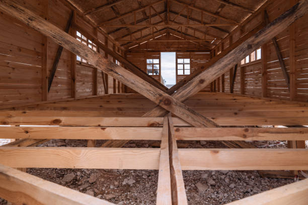Low-angle view of a large exterior wooden wall extending toward the sky. Subtle shadows and natural wear patterns create a textured, minimalist architectural scene.