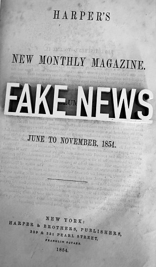Fake news lying on an old page of a magazine of 1854