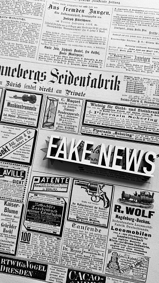 Fake news lying on an old book page with ads of 1899, German language