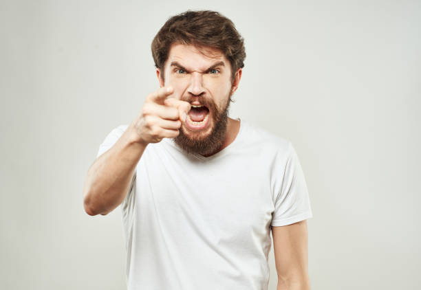 istock A guy in a white T-shirt gestures with his hands on a light background aggression irritability stress 2149863284