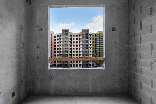 View from the window of an unfinished room onto a construction site.