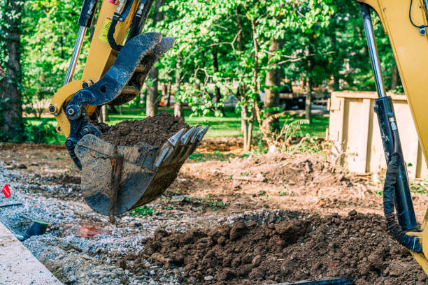 istock Backhoe Lifting a Large Scoop of Dirt at a Construction Site 2149863920