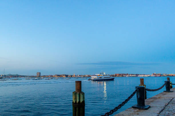 Mooring Bollard Posts and Chain along Boston Harbor and Skyline from Fan Pier Park at Dusk