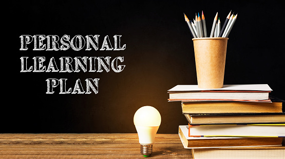 A stack of books with a light bulb on top of them and the words Personal Learning Plan written below