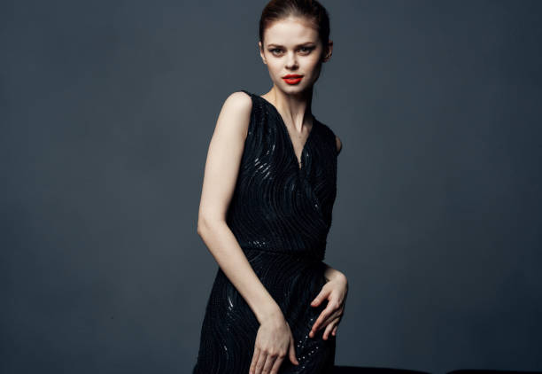 istock Charming lady in a black dress with bare shoulders on a gray background Copy Space 2149868159