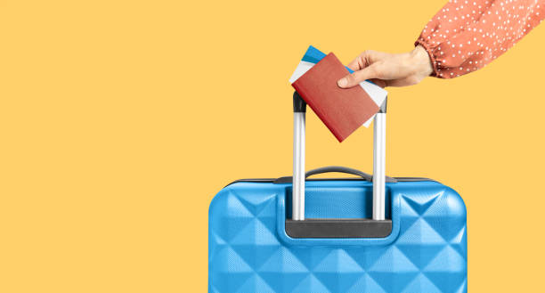 istock female hand with suitcase, passport and tickets 2149868215