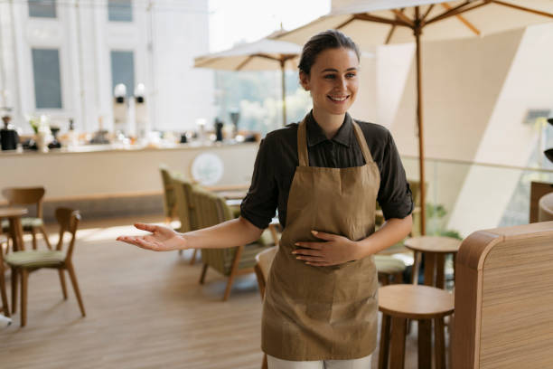 istock Friendly waitress welcoming customers in a cafe 2149873065