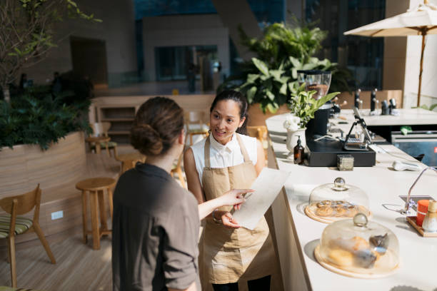 istock Friendly waitress taking order from female guest at coffee shop 2149873069