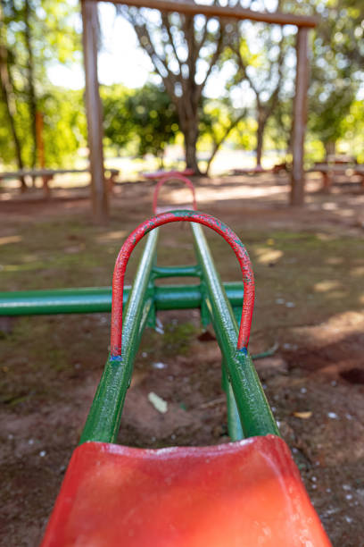 green and red metal seesaw in park playground