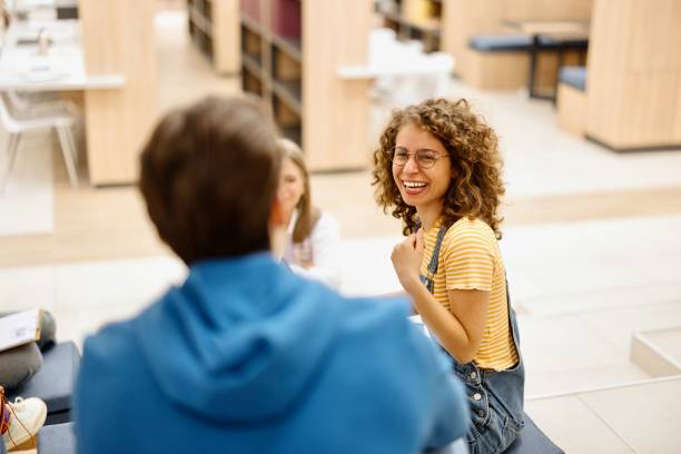 istock Smiling female studying with her friends at the library 2149875670