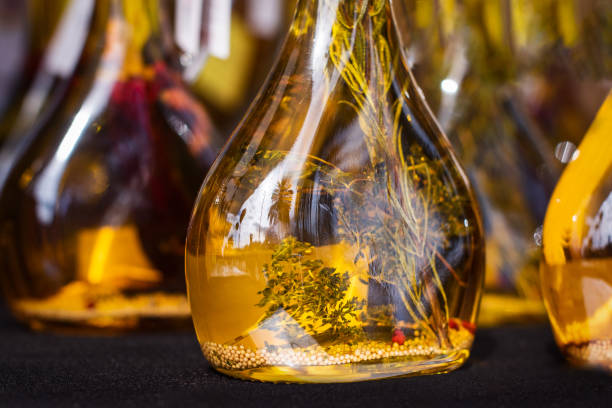 Close up. Olive oil in glass bottles, with herbs inside. Spanish food market.