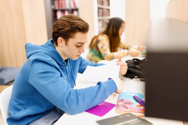 istock Portrait of a young student reading a book at the library 2149876568