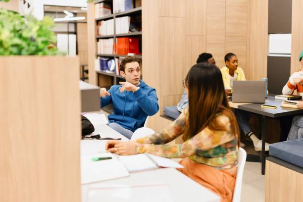 istock Young male and female talking about something at the library 2149876708