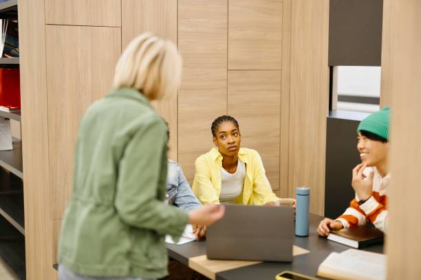 istock Female professor helping her multiracial students with their studies 2149876709