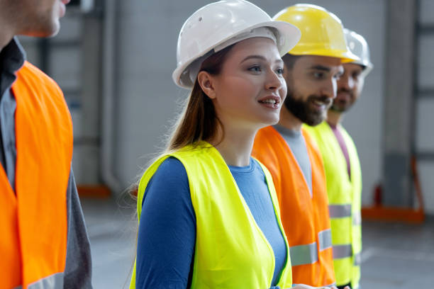 istock Happy engineers, smiling female worker wearing protective helmets talking with colleagues 2149876935