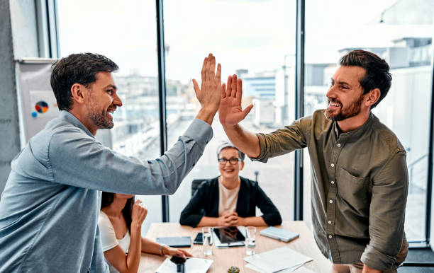 istock Profitable collaboration. Two middle age men standing by opposite sides of table and giving high five with smile. 2149877055