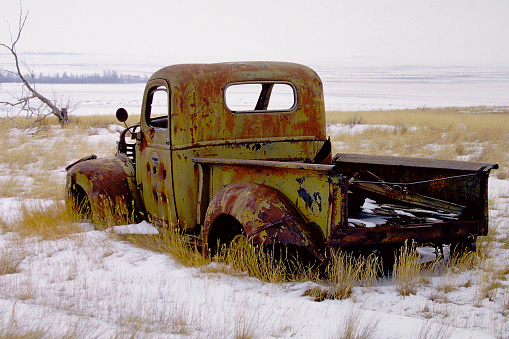 Vintage rusted green car abandoned on the prairies in Saskatchewan