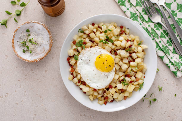 istock Potato hash with bacon or prosciutto served with fried egg on top 2149878661