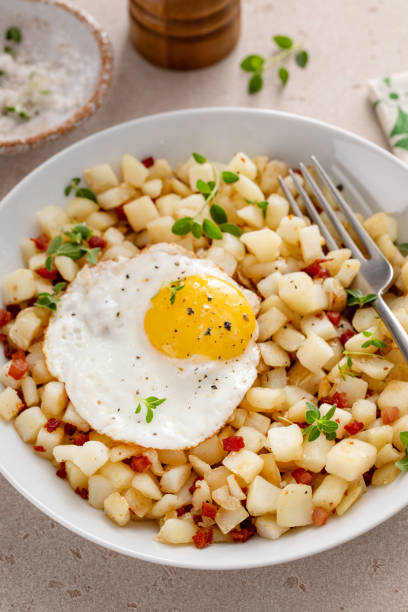 istock Potato hash with bacon or prosciutto served with fried egg on top 2149878683