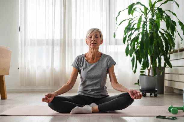 istock Active elderly woman practicing yoga indoors 2149879137
