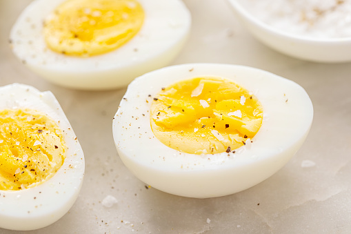Hard boiled eggs peeled and cut in half with salt and pepper