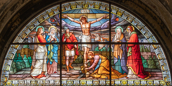 Milan -  The crucifixion in the stained glass in the church Basilica di Santo Stefano Maggiore by Costante Panigati (1898).
