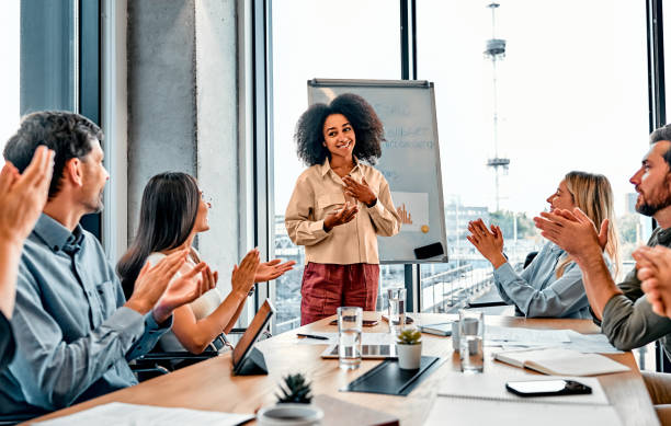 istock Impressive speech. Experienced business couch finishing report in front of workers clapping in delight. Black woman holding hand on chest and feeling grateful for attentive audience looking at her. 2149882310