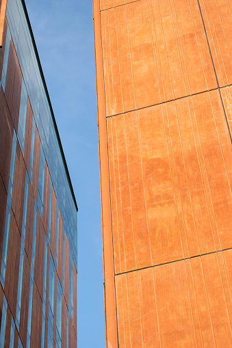 Background of orange and brown architectural facades where the verticality predominates with the sky in the middle.