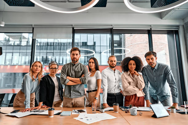 istock Confident professionals at work. Businesspeople in formal clothes standing side by side and looking at camera. Multinational partners feeling motivated making decisions for company development. 2149882828
