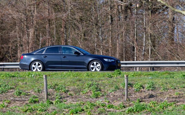 Netherlands, Overijssel, Twente, Wierden, March 19th 2023, side view close-up of a black 2012 Audi 4th generation A6 limousine driving by on the N36 at Wierden, the A6 is made by German car manufacturer Audi AG since 1994, the N36 is a 36 kilometer long highway from Wierden to Ommen