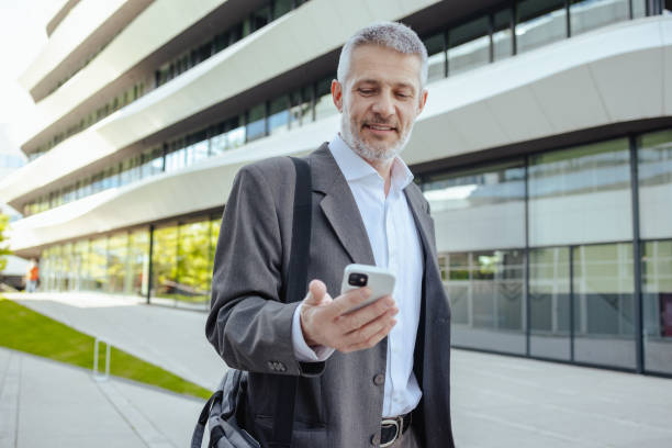 istock Mature businessman using smart phone on the street 2149884218