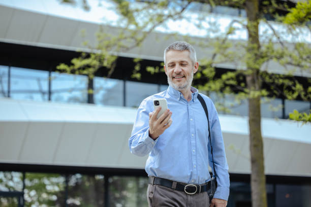 istock Mature businessman using smart phone on the move 2149884364