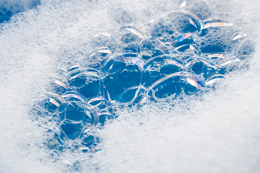 Close-up of soap sud (bubbles foam) in blue colors.