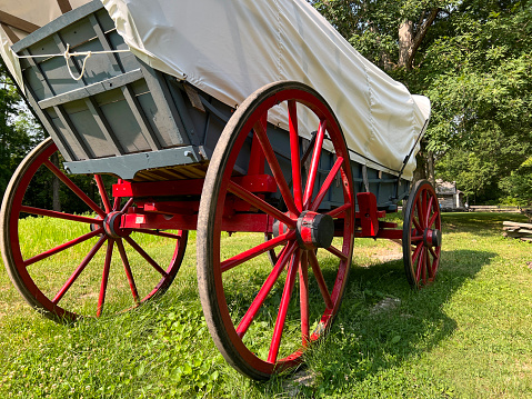 Rear and side partial view of a Horse Drawn Carriage or Covered Wagon.
