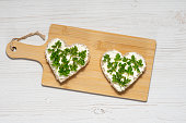 Two heart-shaped sandwiches with cottage cheese and parsley