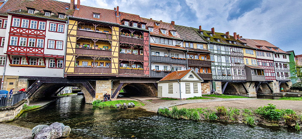 Erfurt, Germany - May 13, 2023: Merchants Bridge, Kraemerbruecke in Erfurt, Germany. It was built in 1325. The only bridge north of the Alps that is built over entirely with houses