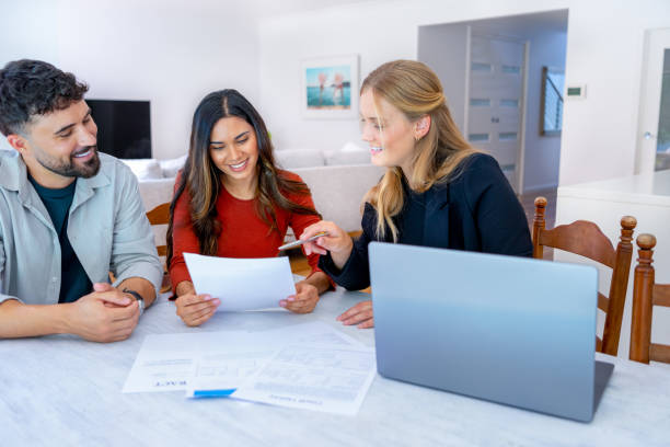 istock Real Estate or Insurance agent with couple looking through documents. 2149889884