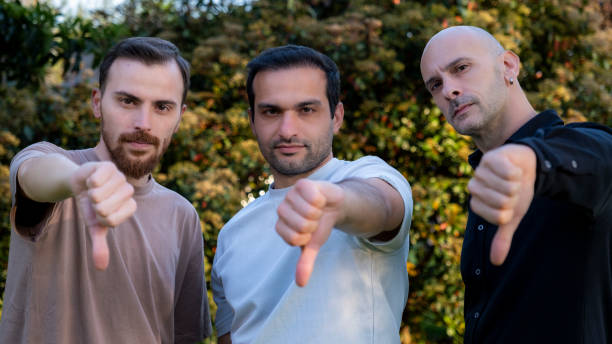 Three men looking at camera and making disapproving gestures and facial expressions, looking determined and saying \