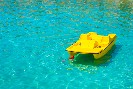 Yellow catamaran on the water. Pedal boat. Active rest on the water. Hobby. Leisure. Entertainment. Summer vacation.