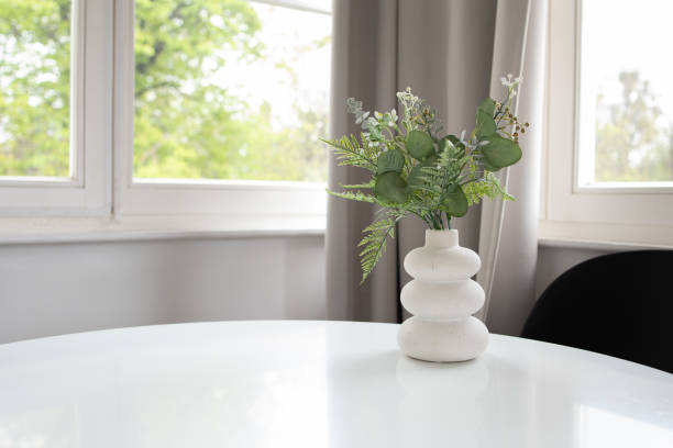 istock Background of white vase with artificial greenery on white table and window at the back 2149892101