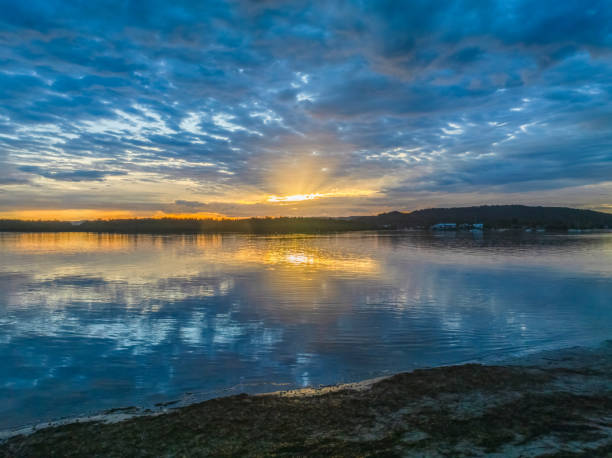 istock Sunrise over the bay water with clouds and reflections 2149901956